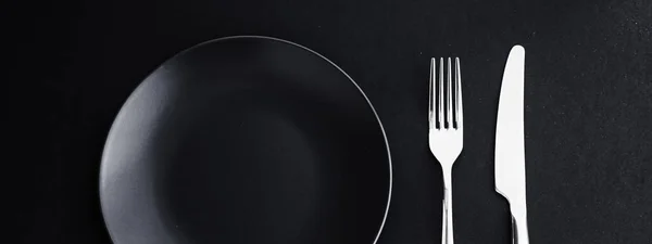 Pratos vazios e talheres em fundo preto, talheres premium para jantar de férias, design minimalista e dieta — Fotografia de Stock