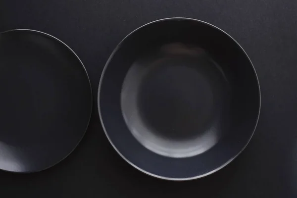 Puste talerze na czarnym tle, naczynia premium na świąteczną kolację, minimalistyczny design i dieta — Zdjęcie stockowe
