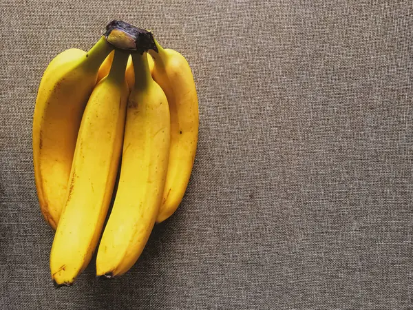 Organické banány na rustikálním plátně pozadí — Stock fotografie