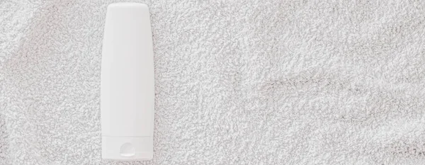 Etiqueta en blanco botella de envase cosmético como maqueta del producto sobre fondo de toalla blanca — Foto de Stock