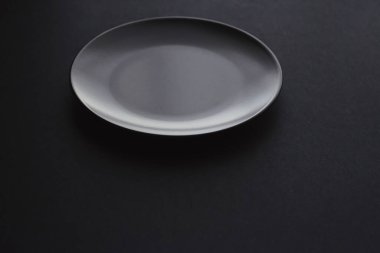 Siyah arka planda boş tabaklar, bayram yemeği için kaliteli bulaşık takımı, minimal tasarım ve diyet
