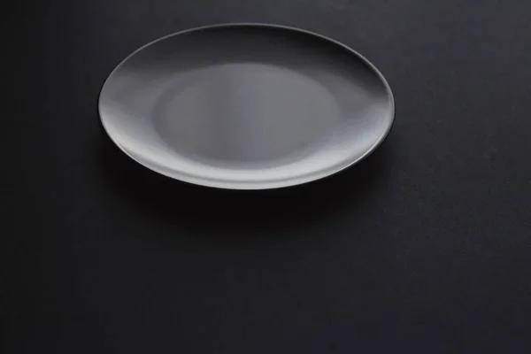 Platos vacíos sobre fondo negro, vajilla premium para la cena de vacaciones, diseño minimalista y dieta —  Fotos de Stock