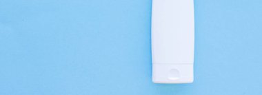 Mavi arkaplanda ürün modeli olarak boş etiket kozmetik kutu şişesi