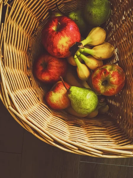 Органические яблоки, груши и бананы на деревенском в плетеной корзине — стоковое фото