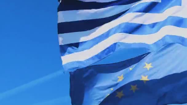 Görög és európai uniós zászlók és kék ég egy szeles napon, utazás és politika — Stock videók