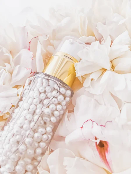 Luxe cosmetische fles als anti-aging huidverzorgingsproduct op achtergrond van bloemen, blanco etiket verpakking voor lichaamsverzorging branding — Stockfoto