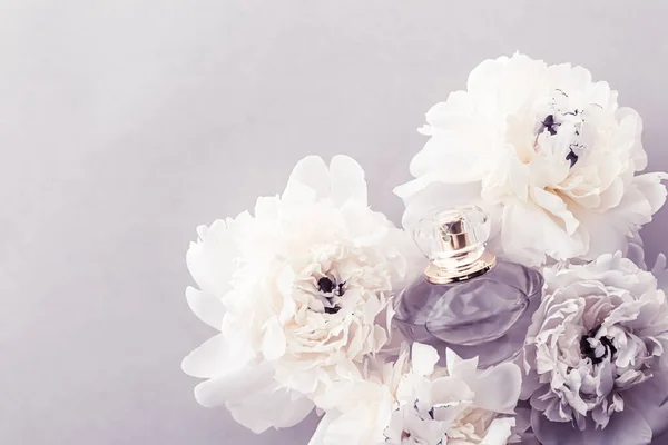 Flacon de parfum violet comme produit de parfum de luxe sur fond de fleurs de pivoine, annonce de parfum et marque de beauté — Photo