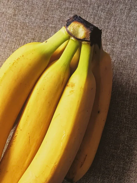 Biologische bananen op rustieke linnen achtergrond — Stockfoto