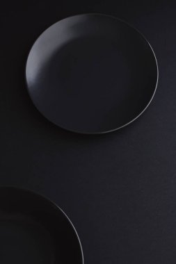 Siyah arka planda boş tabaklar, bayram yemeği için kaliteli bulaşık takımı, minimal tasarım ve diyet