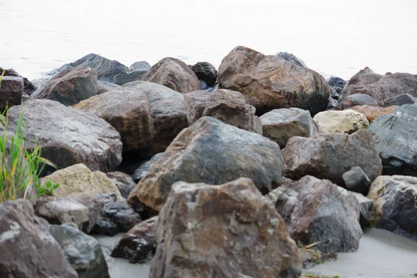 Камни на пляже под входящей волной — стоковое фото