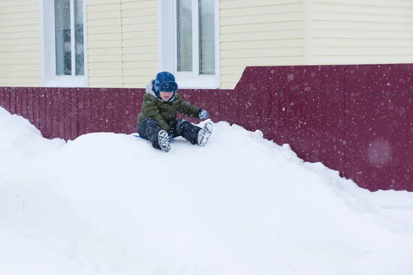 Le petit garçon luge avec glissades de neige — Photo