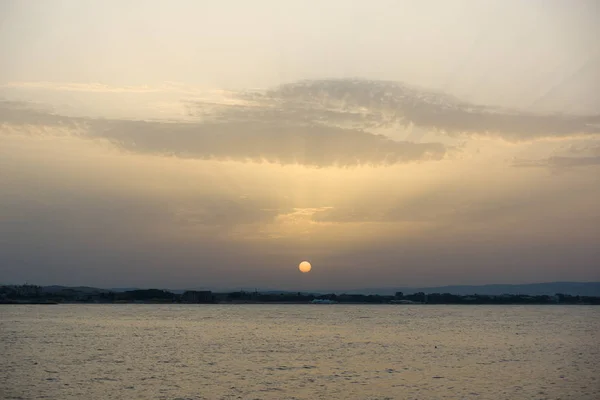 Mar calmo com o sol sentado nele — Fotografia de Stock