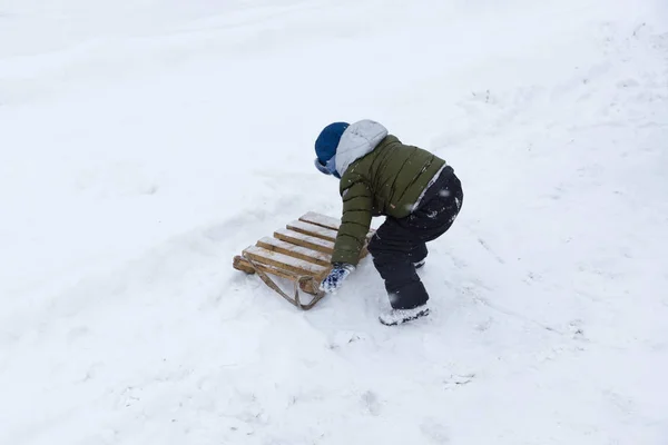 Jongen met sleeën zijn gemaakt van planken — Stockfoto