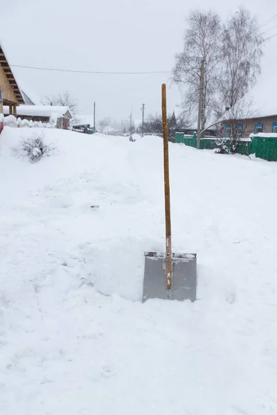 Schaufel ragt aus dem Schnee — Stockfoto