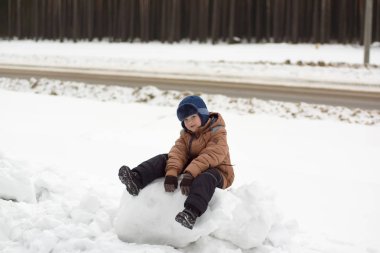 bir kış sokakta yürüyen çocuk
