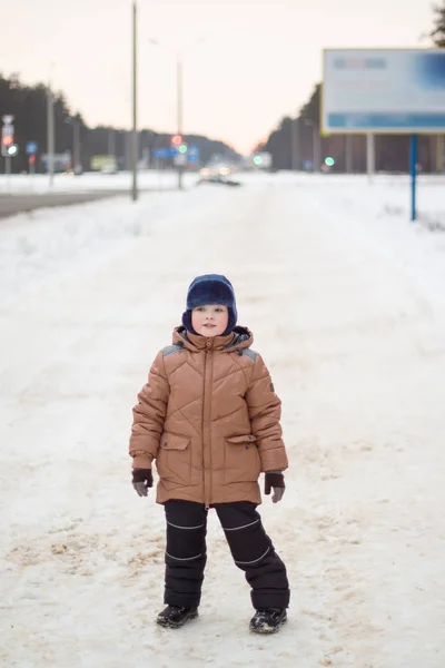 Ragazzo che cammina su una strada invernale — Foto Stock
