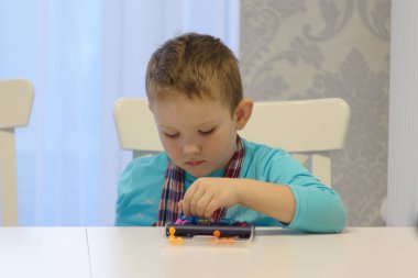 bir tablo çalmaya oturan çocuk