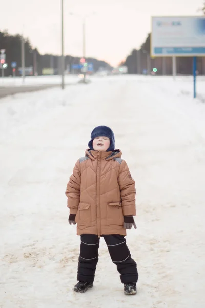 Junge läuft auf winterlicher Straße — Stockfoto