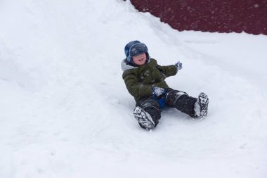 Çocuk bir kar tepe ile sürme