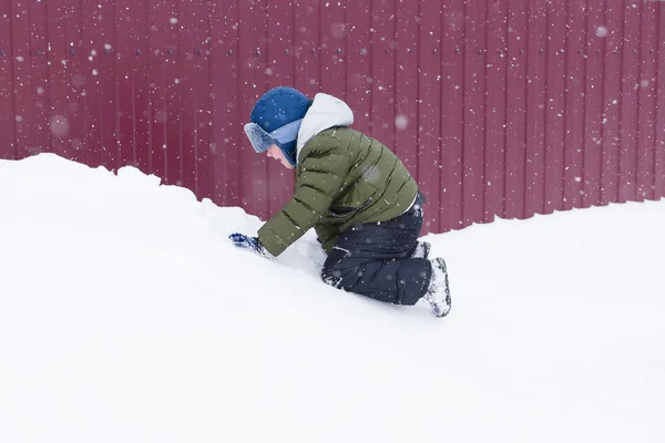 Çocuk bir sürücü için karlı bir tepe üzerinde gider. — Stok fotoğraf