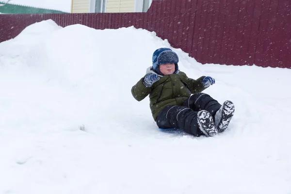 少年は、雪に覆われた丘の上にドライブに行く — ストック写真