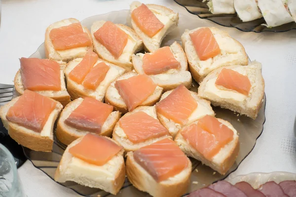 Bocadillos con pescado rojo dispuestos en un plato — Foto de Stock