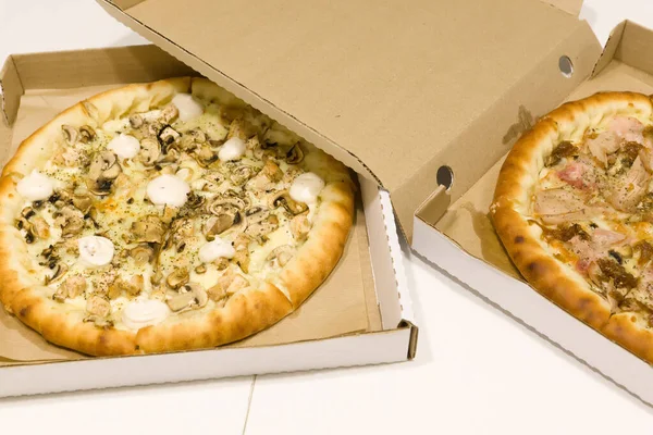 big pizza with mushrooms in a cardboard box