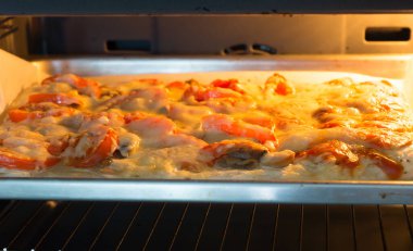 Sıcak bir fırında taze pizza pişirilir.