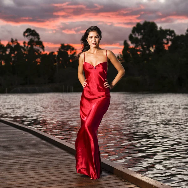 Hermosa joven en los jardines con un largo rojo de seda dre —  Fotos de Stock