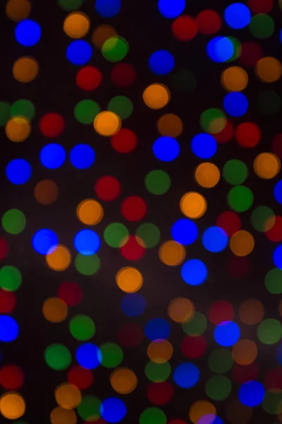 Bokeh de Natal de cor em um fundo escuro . — Fotografia de Stock