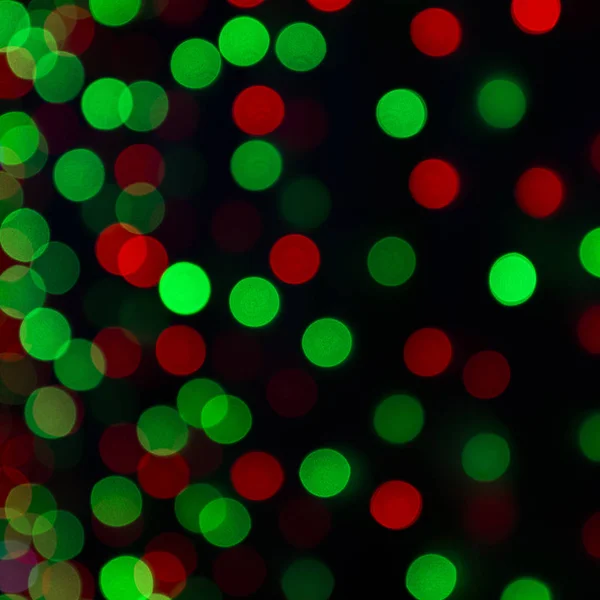 Farbiges Weihnachtsbokeh auf dunklem Hintergrund. — Stockfoto