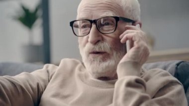 smartphone üzerinde konuşan gülümseyen kıdemli adam