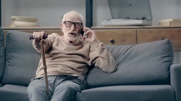 Homme Âgé Parlant Sur Smartphone Sur Canapé — Video