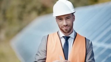 gülümseyen iş adamı güneş pili modelini gösteriyor 