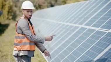 Güneş panelleri etrafında dans eden gülümseyen iş adamları 