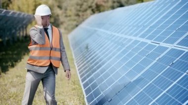 Güneş panelleri etrafında dans eden gülümseyen iş adamları 