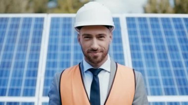 gülümseyen iş adamı güneş pili modelini gösteriyor 