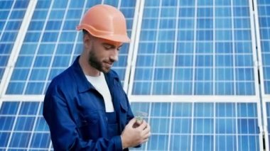 gülümseyen mühendis güneş paneli modelini gösteriyor 