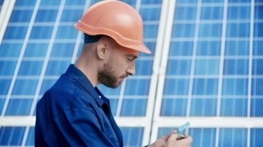 gülümseyen mühendis güneş paneli modelini gösteriyor 