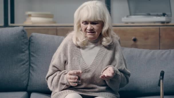 Bunamış Yaşlı Bir Kadın Elinde Haplarla Kameraya Bakıyor — Stok video
