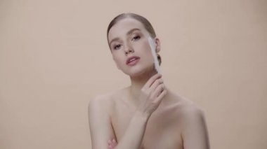 Neşeli kız bej renginde tüy tutuyor 