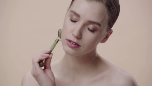 Nackte Frau Mit Jade Rolle Isoliert Auf Beige — Stockvideo