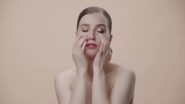 Naken Kvinna Gör Ansiktsmassage Isolerad Beige — Stockvideo