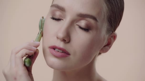 Close Woman Using Jade Roller Isolated Beige — Stock Video
