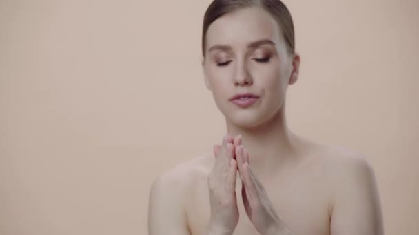 Schöne Frau Die Gesichtscreme Isoliert Auf Beige Anwendet — Stockvideo