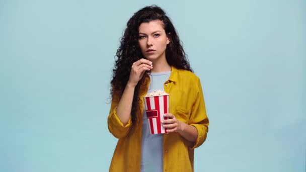 Молода Жінка Їсть Попкорн Ізольовано Синьому — стокове відео