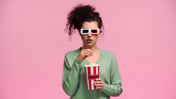 戴着3D眼镜害怕的女孩吃着用粉红隔开的爆米花 — 图库视频影像