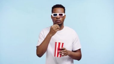 Özenli afro-amerikan adam mavi üzerine izlenmiş bir film izliyor.