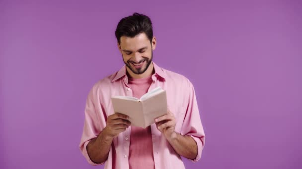 Lächelnder Mann Liest Buch Isoliert Auf Violett — Stockvideo