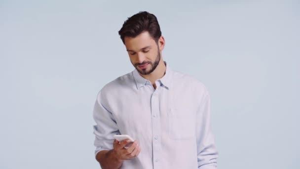 Χαμογελαστός Άνθρωπος Δείχνοντας Δάχτυλο Στο Smartphone Απομονώνονται Μπλε — Αρχείο Βίντεο